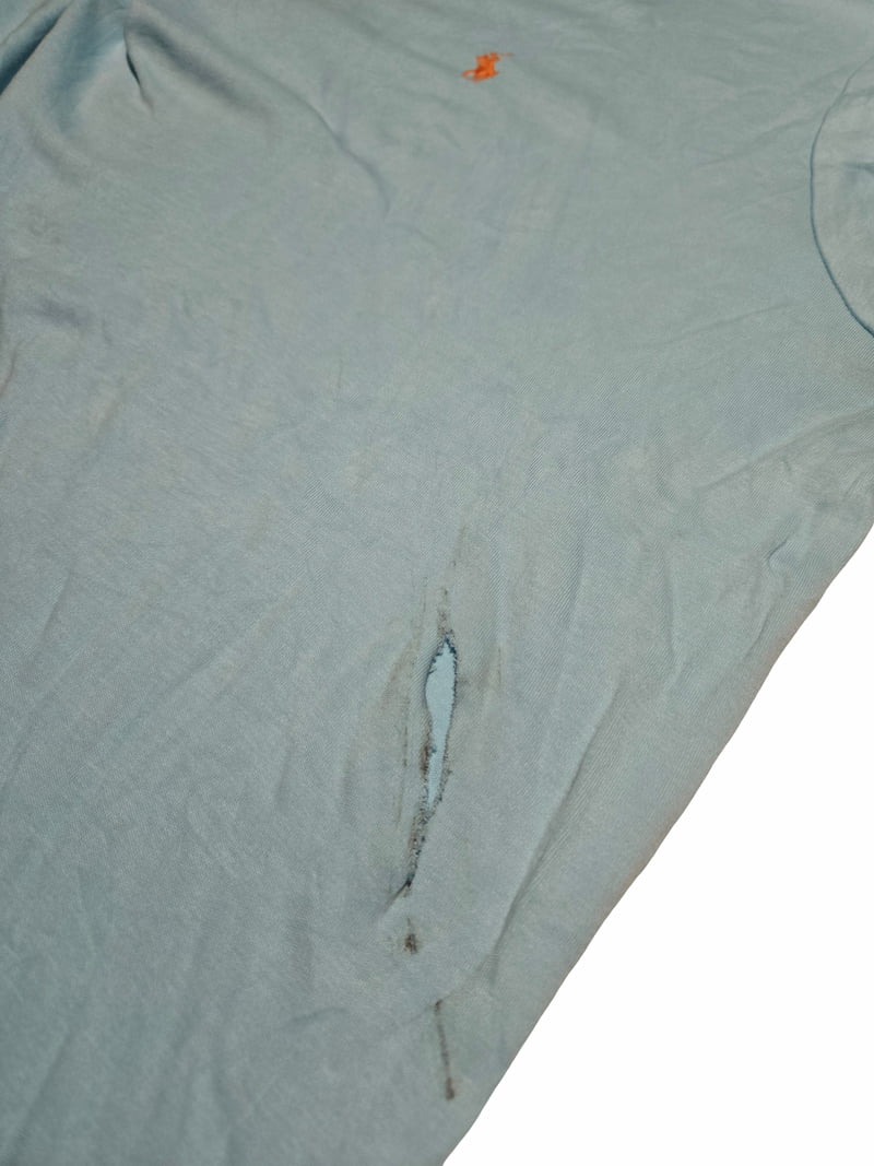 Détail d'un défaut prononcé sur un polo Ralph Lauren issu de notre sélection Grade C.