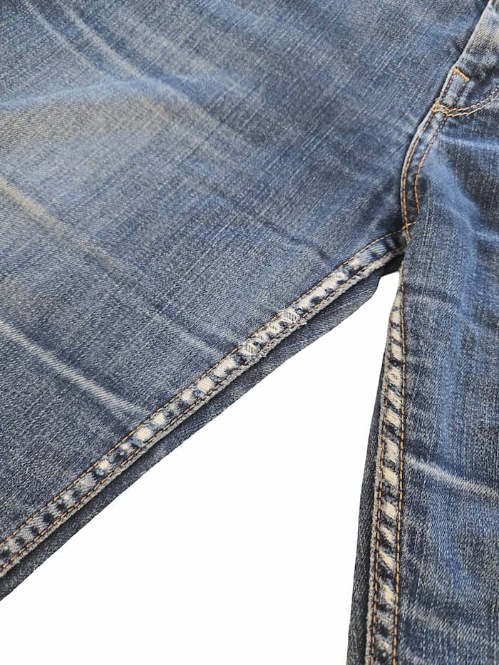 Détail zoomé d'un défaut sur un jean Levi's issu d'un lot Grade B.