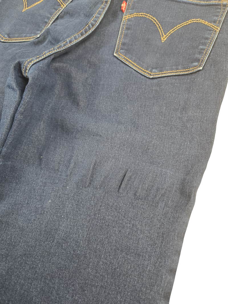 Détail zoomé d'un défaut sur un jean Levi's issu d'un lot Grade B.