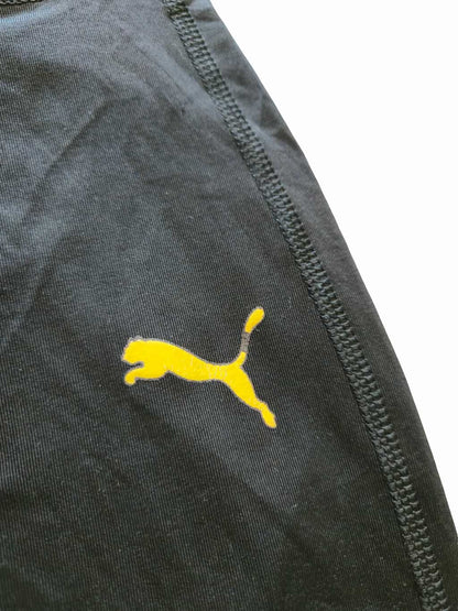 Détail zoomé d'un défaut sur un legging puma noir issu d'un lot Grade B.