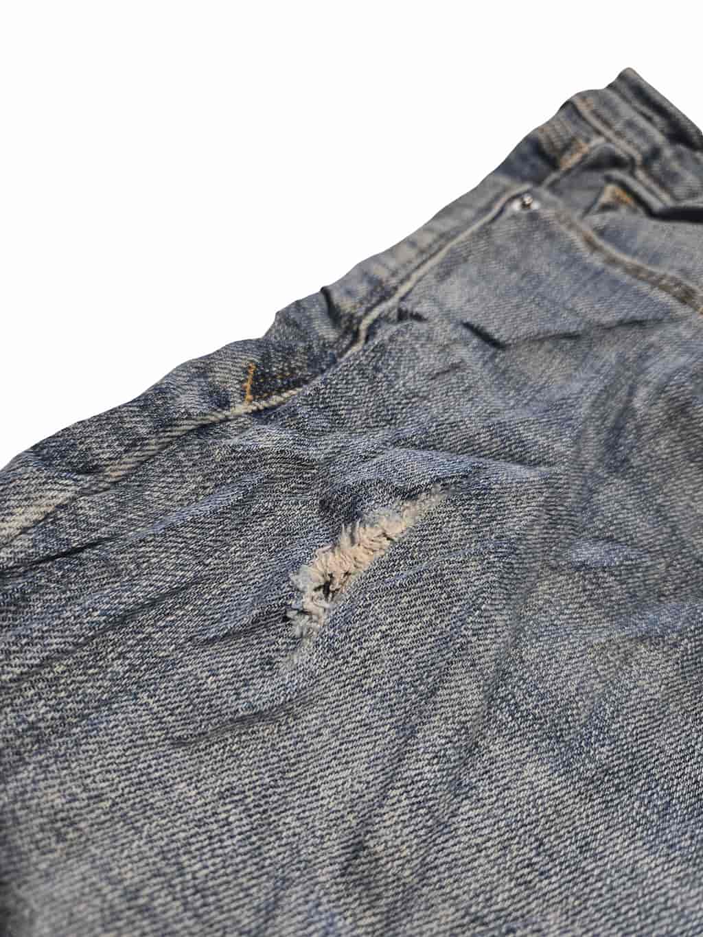 Détail zoomé d'un défaut sur un pantacourt Lee et Levi's issu d'un lot Grade B.
