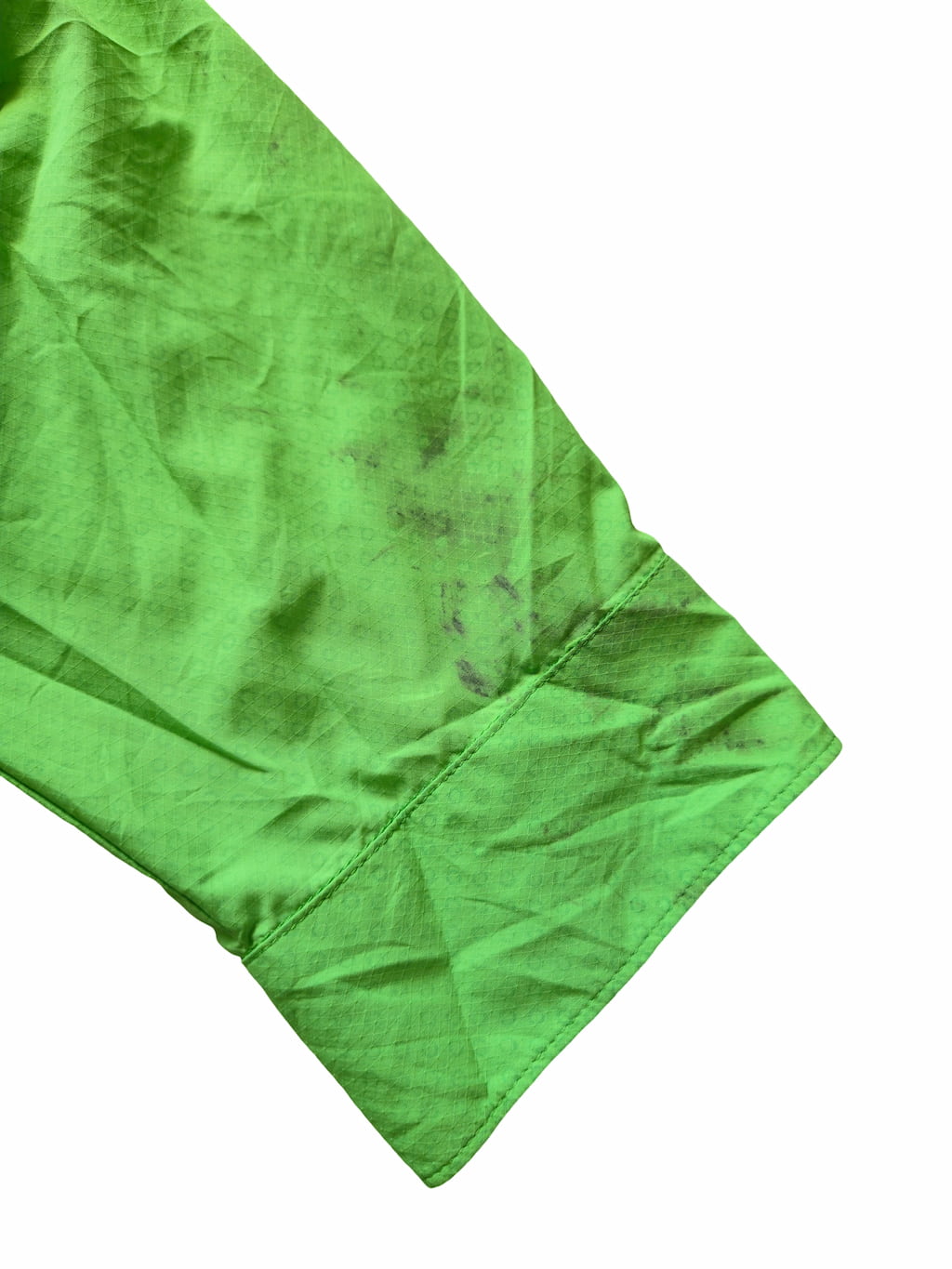 Détail zoomé d'un défaut sur une veste under armour verte issu d'un lot Grade B.